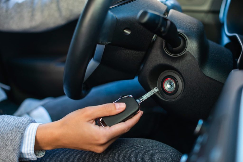 Transponder key fob held beside a car ignition during key programming in Vancouver