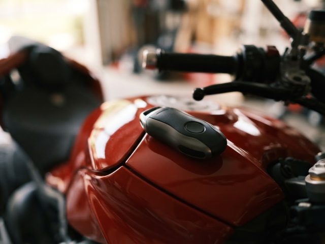 Smart key fob resting on the tank of a red motorcycle